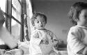 Portrait of baby by the window holding card in hands