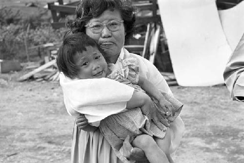 Portrait of woman carrying baby in arms