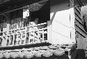 Woman looking from porch above shop