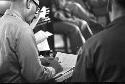 Man sitting in chair writing on paper in lap