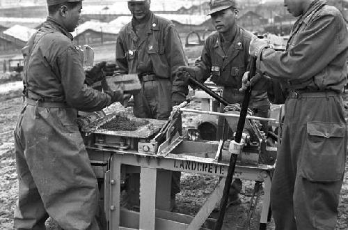 Workers using landcrete machine