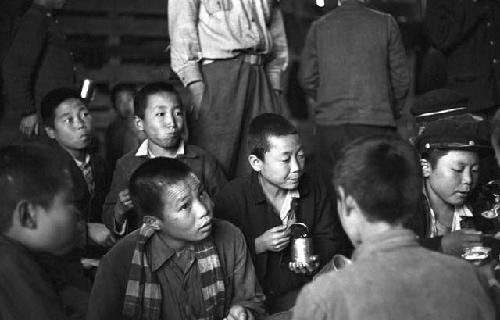 Portrait of children eating food from cans