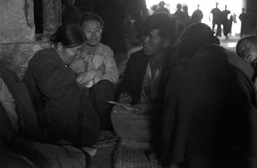 Portrait of men and woman gathered around sitting on ground