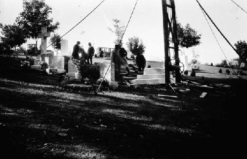 Crew installing gravestone in cemetery