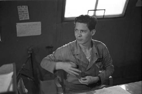 Soldier sitting reaching in his shirt pocket