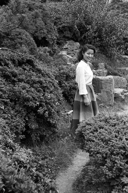 Girl walking along path in a dress and white shirt