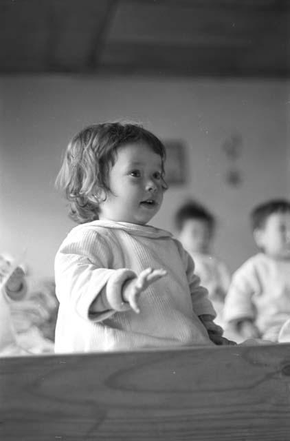 Portrait of baby girl raising arm with open hand