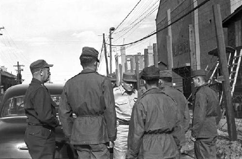 Soldiers outside of building having meeting in the street