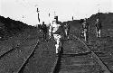 Soldiers walking along train tracks