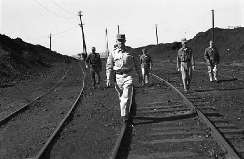 Soldiers walking along train tracks