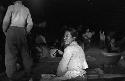 Woman sitting on ground smoking long pipe