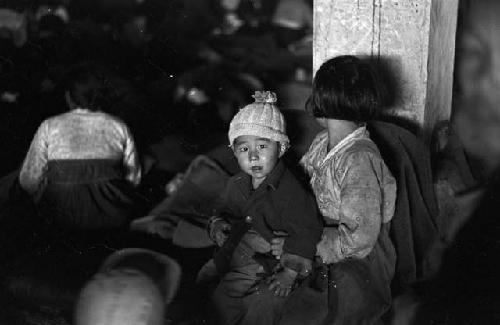 Portrait of littlle boy sitting in other child's lap