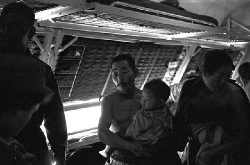 Man in line holding baby waiting for aid