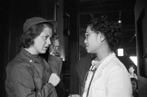 Portrait of woman and nurse speaking in hallway