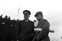 Portrait of two officers outside next to boat