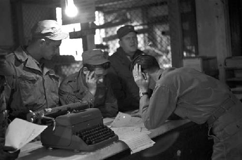 Soldiers at counter looking over papers