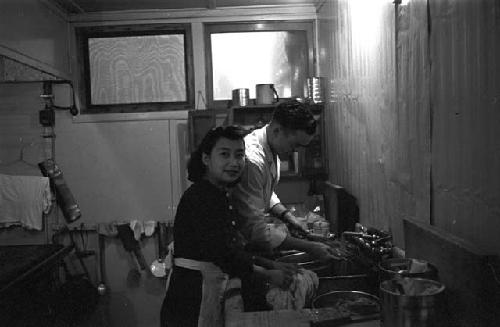 Man and woman cleaning dishes in dishroom