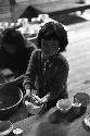 Girl at dinner table holding food in bowl