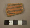 Ceramic rim sherd, black on orange interior, fire clouded exterior