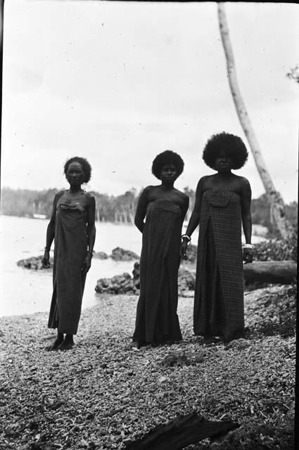 Three women in dresses on beach