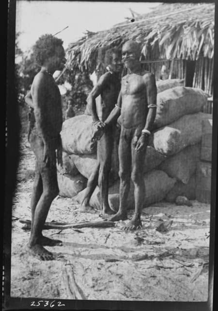 Native Men in front of Hut