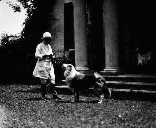 Woman with dog in front of house