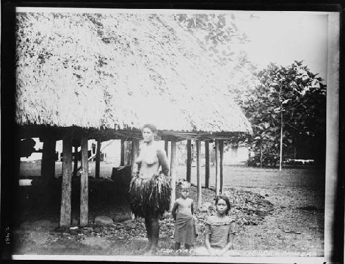 Woman and two children outside hut