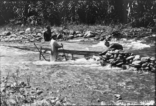 Fish trap being set over river in Peru