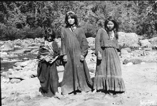 Man, woman, and child on bank of river