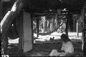 Woman working at loom in hut