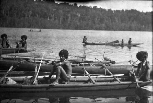 Men standing on boats and canoes