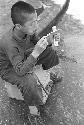 Kid sitting on box holding money playing with toy