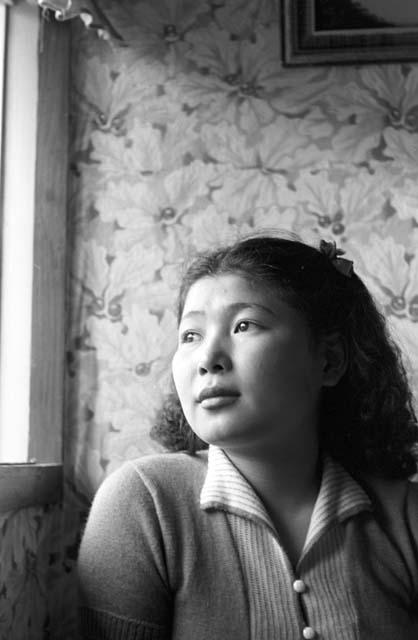 Portrait of woman sitting looking outside by window