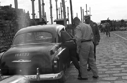 Soldiers on road getting into car