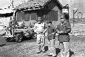 Soldiers standing near jeep outside