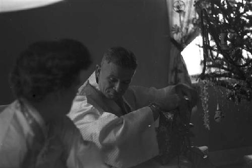 Man in gown sitting going through gifts