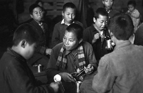 Portrait of children eating food from cans