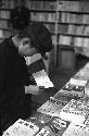 Boy inside shop flipping through pages