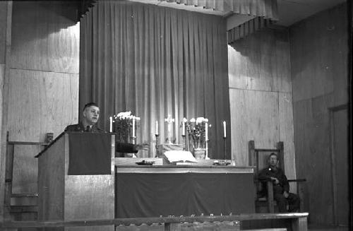 Paostor/Priest preaching at podium 3