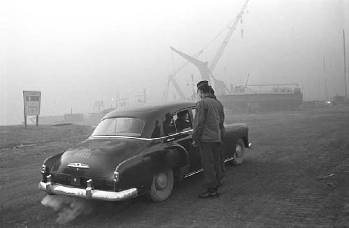 Portrait of soldier speaking to passengers in vehicle