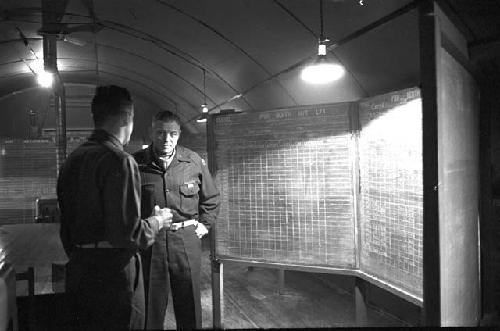 Soldiers in room reviewing work on board 2