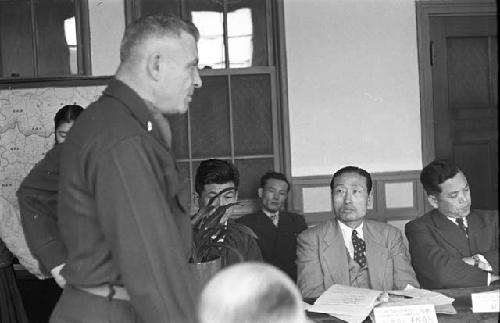 Portrait of suits looking at general speaking during meeting