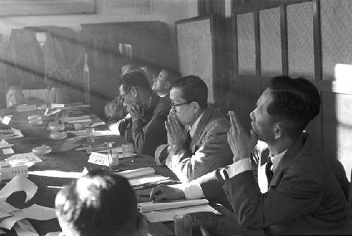 Portrait of suits sitting across table during meeting