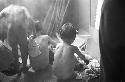 Nude children removing wet clothes