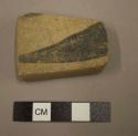 Ceramic body sherd, reworked, trapezoidal, black on buff