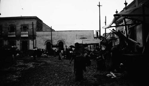 People walking through street, vendors in stalls