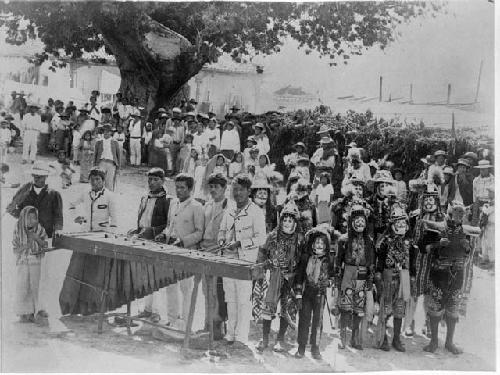 Fiesta with musicians and masked figures