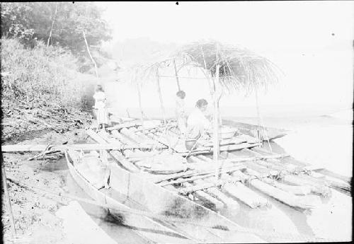 River with men working on boats and canoes