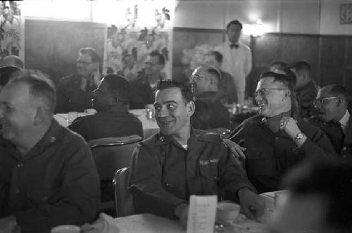 Two tables filled with men enjoying themselves