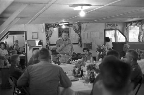 Soldier standing at table addressing audience at banquet